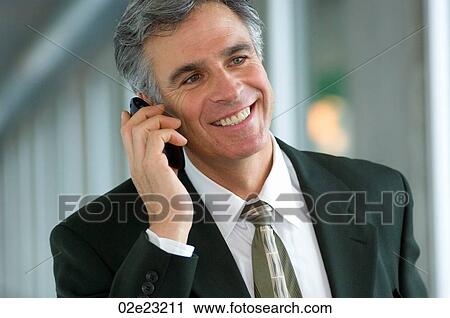 Stock Image - Businessman talking cellular PDA.. Fotosearch