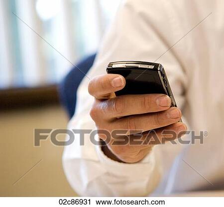 Stock Image - Businessman texting using Blackberry PDA.. Fotosearch
