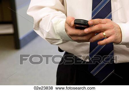 Stock Photo - Businessman using PDA in office.. Fotosearch