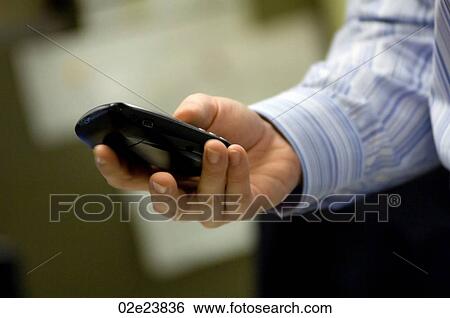 Stock Photograph - Businessman using PDA while in office.. Fotosearch