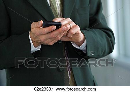 Stock Photo - Businessman, using wireless PDA.. Fotosearch