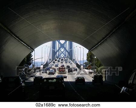 Cars driving on a five lane highway through tunnel leading onto a bridge View Large Photo Image Stock Image - Cars driving on a five lane highway through tunnel leading onto a bridge. Fotosearch