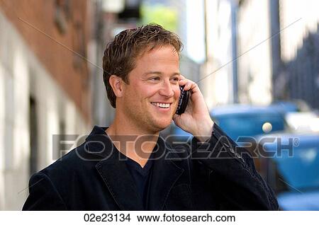 Picture - Casually dressed businessman talking on cellular PDA.. Fotosearch