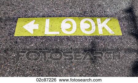 Stock Photograph - Caution to look both ways street pavement sign.. Fotosearch
