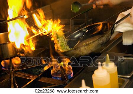 Chef cooking over a flaming stove. View Large Photo Image Stock Photo - Chef cooking over a flaming stove.. Fotosearch