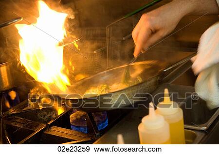 Chef cooking with a flaming pan. View Large Photo Image Stock Photo - Chef cooking with a flaming pan.. Fotosearch