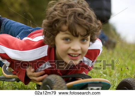 Stock Photo - Close-up of a boy lying on a mountain board. Fotosearch