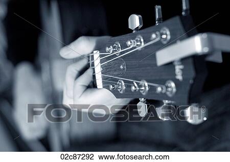 Stock Image - Close-up of acoustic guitar playing.. Fotosearch