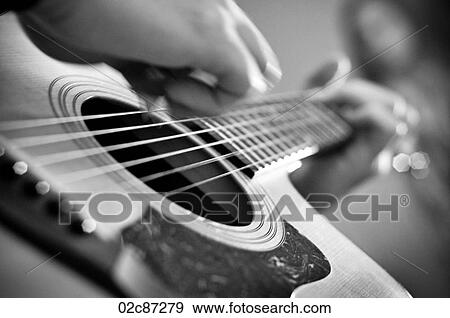 Stock Photo - Close-up of acoustic guitar playing.. Fotosearch