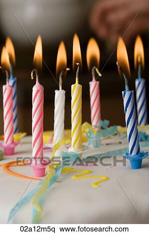 Close-up of burning candles on a birthday cake View Large Photo Image Stock Photography - Close-up of burning candles on a birthday cake. Fotosearch