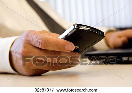 Stock Photo - Close-up of male hand holding PDA device.. Fotosearch