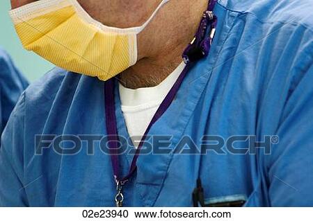 Stock Image - Close-up of surgeon with scrubs and mask.. Fotosearch