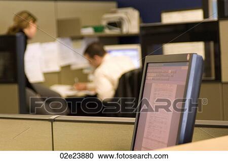 Stock Image - Co-workers in office cubicle. Fotosearch