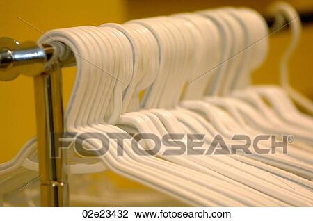 Coat hangers hanging on rack. View Large Photo Image Stock Image - Coat hangers hanging on rack.. Fotosearch