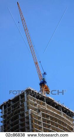 Stock Photo - Crane working on partly-constructed building.. Fotosearch
