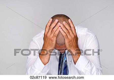 Stock Photo - Depressed businessman holding head with hands.. Fotosearch