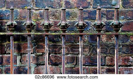 Detail of old rod iron fence against brick wall. View Large Photo Image Stock Photograph - Detail of old rod iron fence against brick wall.. Fotosearch
