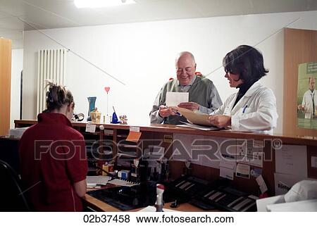 Stock Photo - Doctor and patient at the reception. Fotosearch