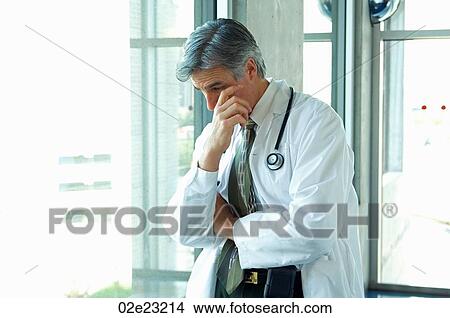 Doctor having a personal moment of sadness. View Large Photo Image Picture - Doctor having a personal moment of sadness.. Fotosearch