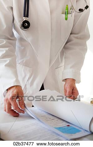 Doctor reading patients file View Large Photo Image Stock Photo - Doctor reading patients file. Fotosearch