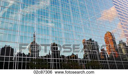 Stock Photograph - Empire State Building reflecting in mirrored downtown building, New York City, USA.. Fotosearch