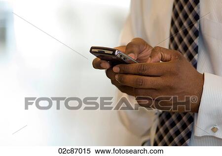 Stock Photography - Executive using Blackberry PDA smart phone.. Fotosearch