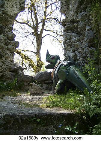 Fake dinosaur by the stone wall View Large Photo Image Stock Photo - Fake dinosaur by the stone wall. Fotosearch