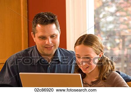 Father and daughter working on wireless laptop computer at home. View Large Photo Image Stock Image - Father and daughter working on wireless laptop computer at home.. Fotosearch
