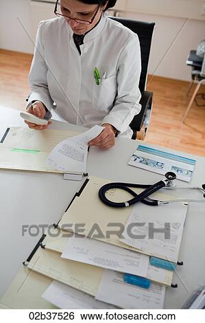 Stock Photograph - Female doctor at her desk. Fotosearch