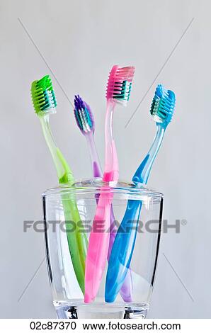 Four different colored toothbrushes in clear toothbrush holder. View Large Photo Image Stock Image - Four different colored toothbrushes in clear toothbrush holder.. Fotosearch