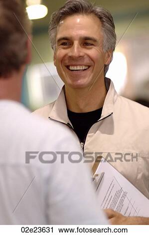 Stock Image - Friendly man speaking to another.. Fotosearch