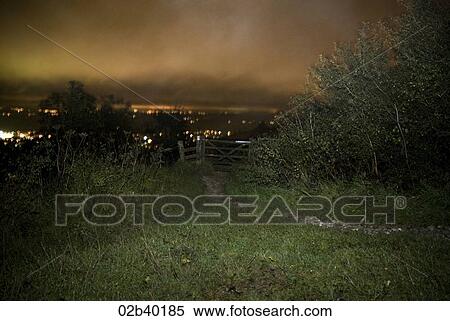 Stock Photography - Gate at the end of a field, night time. Fotosearch