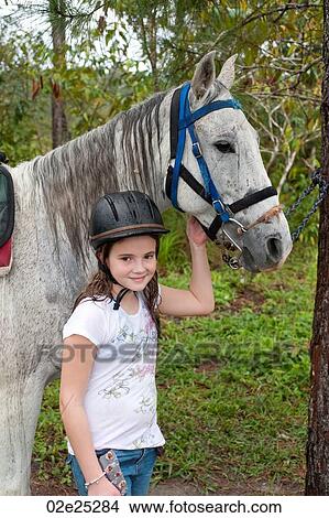 Girl holding bridle of horse at Mountain Pine Ridge Reserve in Belize View Large Photo Image Picture - Girl holding bridle of horse at Mountain Pine Ridge Reserve in Belize. Fotosearch
