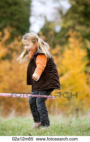 Stock Photography - Girl playing with a plastic hoop. Fotosearch