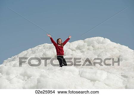 Girl standing on a pile of snow at Winnipeg Beach, Manitoba, Canada View Large Photo Image Picture - Girl standing on a pile of snow at Winnipeg Beach, Manitoba, Canada. Fotosearch