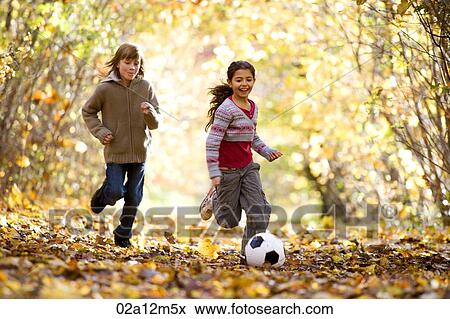 Girls playing with a soccer ball in a park View Large Photo Image Stock Photo - Girls playing with a soccer ball in a park. Fotosearch