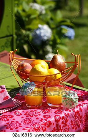 Glasses of orange juice and fruit on a table View Large Photo Image Stock Photograph - Glasses of orange juice and fruit on a table. Fotosearch