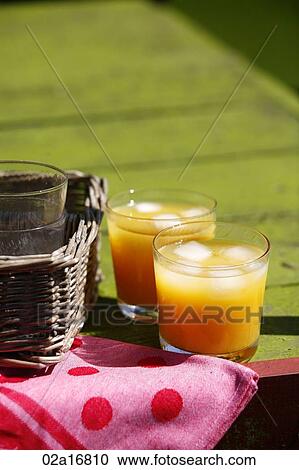Stock Image - Glasses of orange juice on a table. Fotosearch