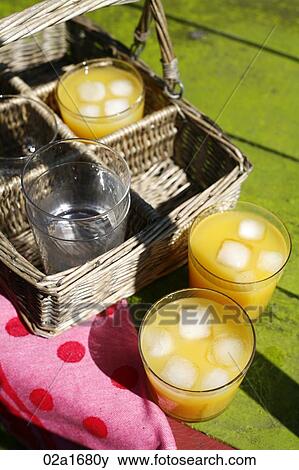 Glasses of orange juice on a table View Large Photo Image Stock Photo - Glasses of orange juice on a table. Fotosearch