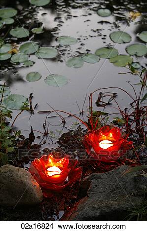 Glowing red candles by water View Large Photo Image Picture - Glowing red candles by water. Fotosearch