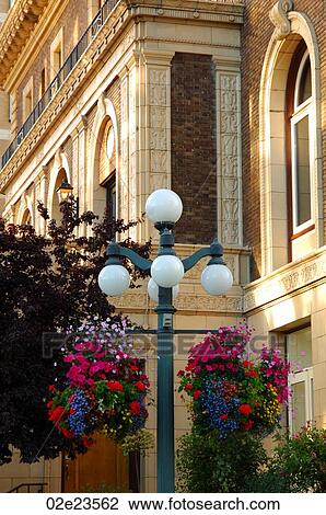 Stock Image - Hanging flower baskets, heritage architecture.. Fotosearch