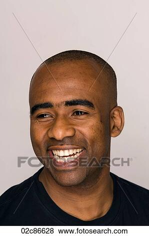 Stock Photo - Headshot of African-American man smiling and looking away.. Fotosearch