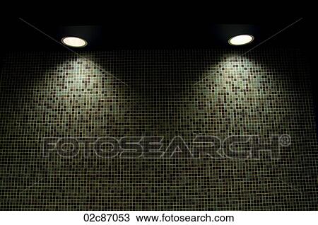Stock Image - Illuminating Pot-lights shining down on a tiled wall.. Fotosearch