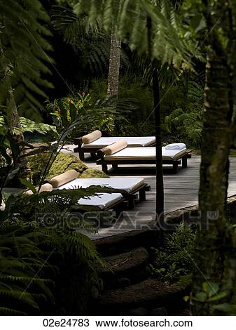 Stock Image - Lounge chairs on deck in Bali. Fotosearch