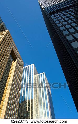 Stock Image - Low angle view of office towers with blue sky.. Fotosearch