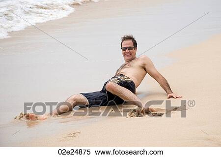 Man laying on the sand along shoreline in Bali View Large Photo Image Stock Photography - Man laying on the sand along shoreline in Bali. Fotosearch