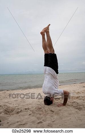 Man standing on his head on beach at Placencia Belize View Large Photo Image Stock Photo - Man standing on his head on beach at Placencia Belize. Fotosearch
