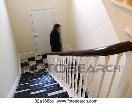 Man walking down checkered staircase View Large Photo Image Stock Photography - Man walking down checkered staircase. Fotosearch