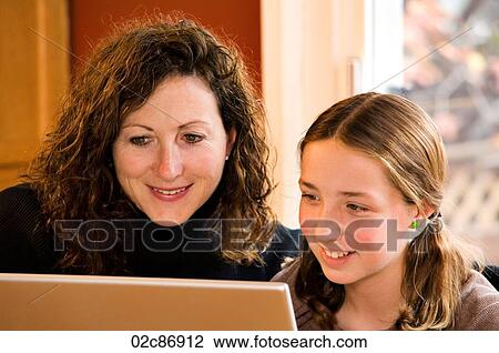 Stock Image - Mom and daughter working on computer laptop.. Fotosearch