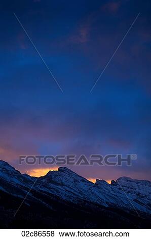 Stock Photo - Morning sun over Mount Rundle, Banff National Park, Alberta Canada.. Fotosearch